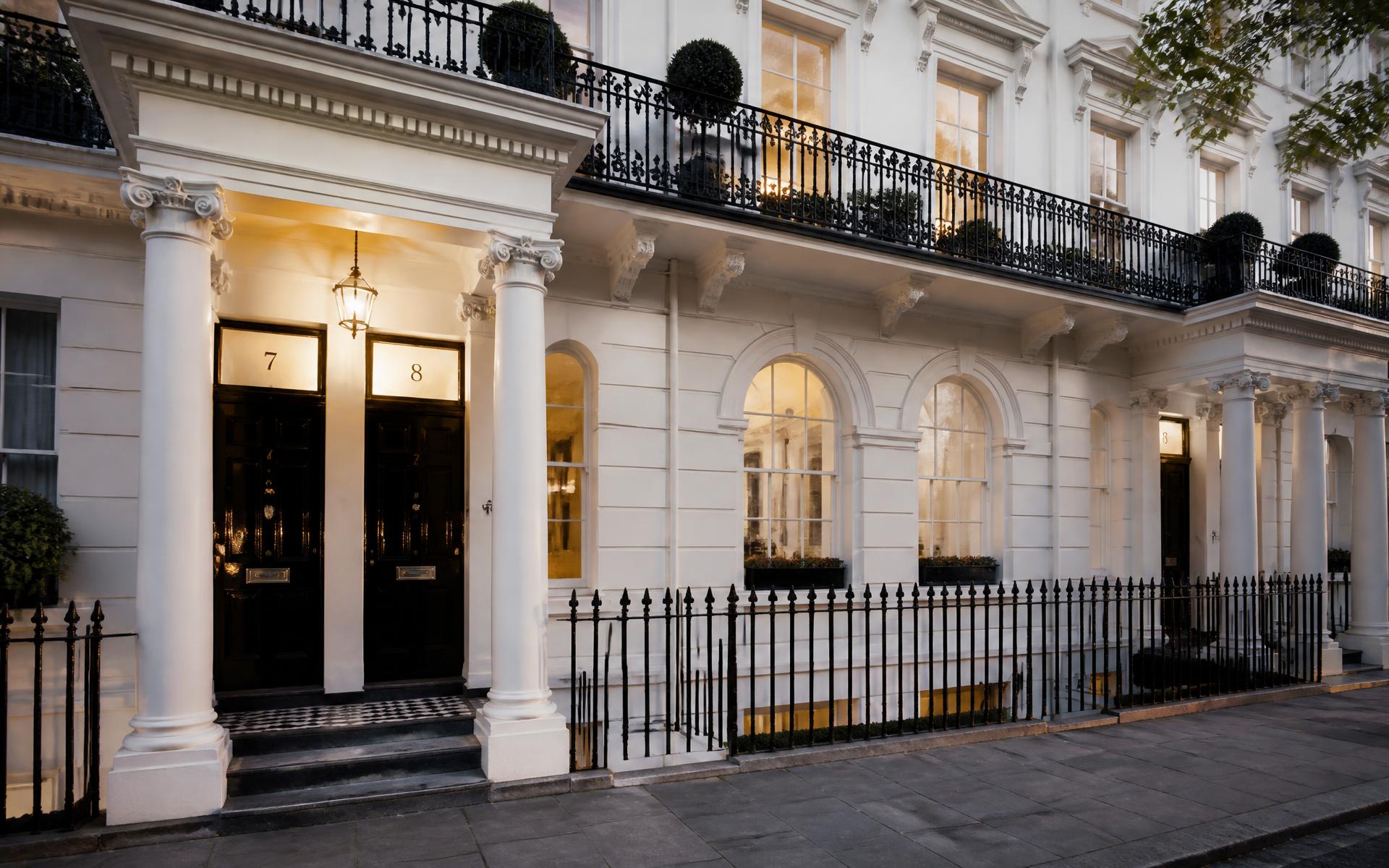 White stucco Georgian townhouses with black railings in Kensington, London